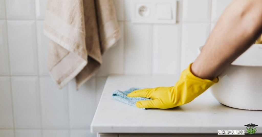 cleaning bathroom sink with yellow gloves